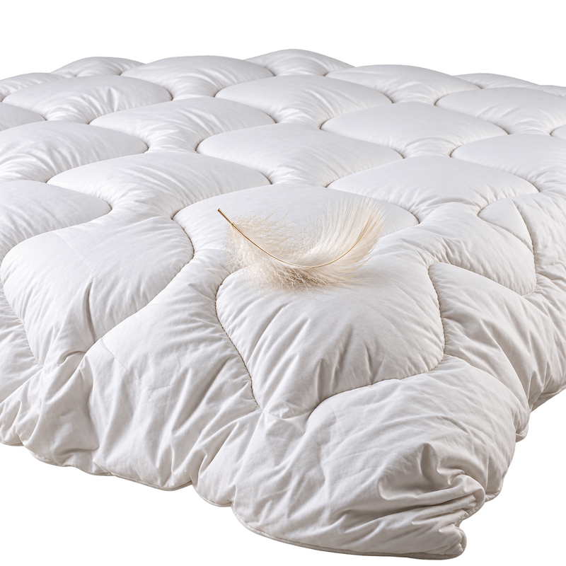 A white quilted mattress topper or comforter shown from a side view on a solid white background.